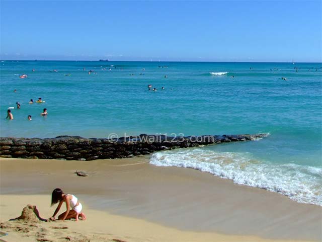 ワイキキビーチの波打ち際で遊ぶ子供