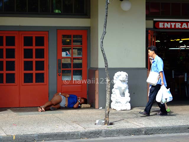 チャイナタウンの路上で寝ている女性