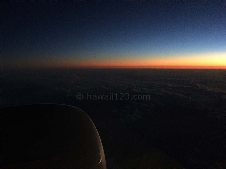 飛行機の窓から見る夜明け